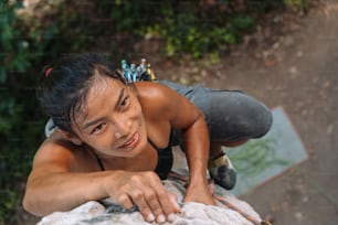 a woman is smiling and leaning on a rock