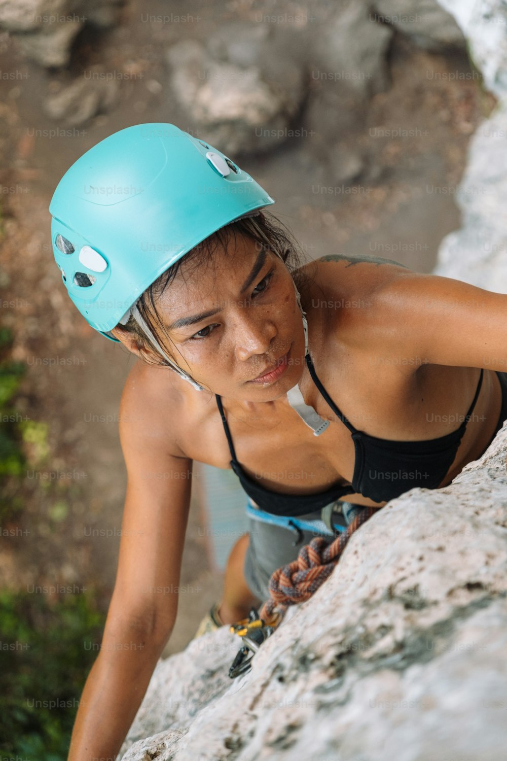 a woman climbing up the side of a mountain