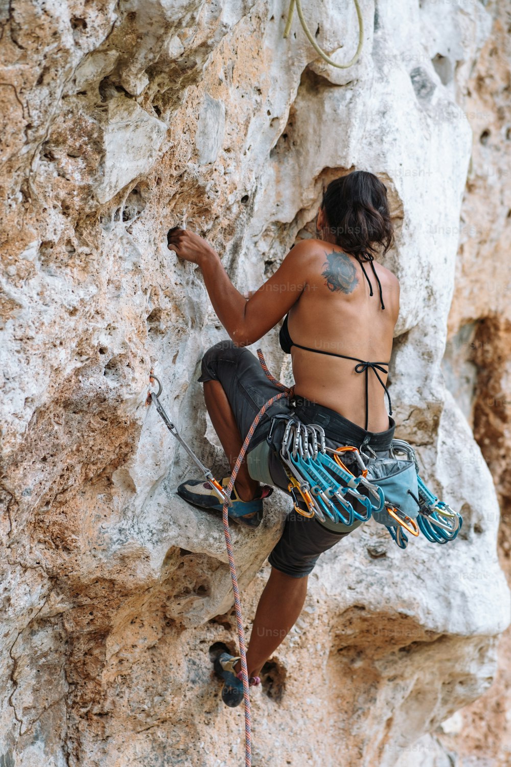 a woman climbing up a rock face