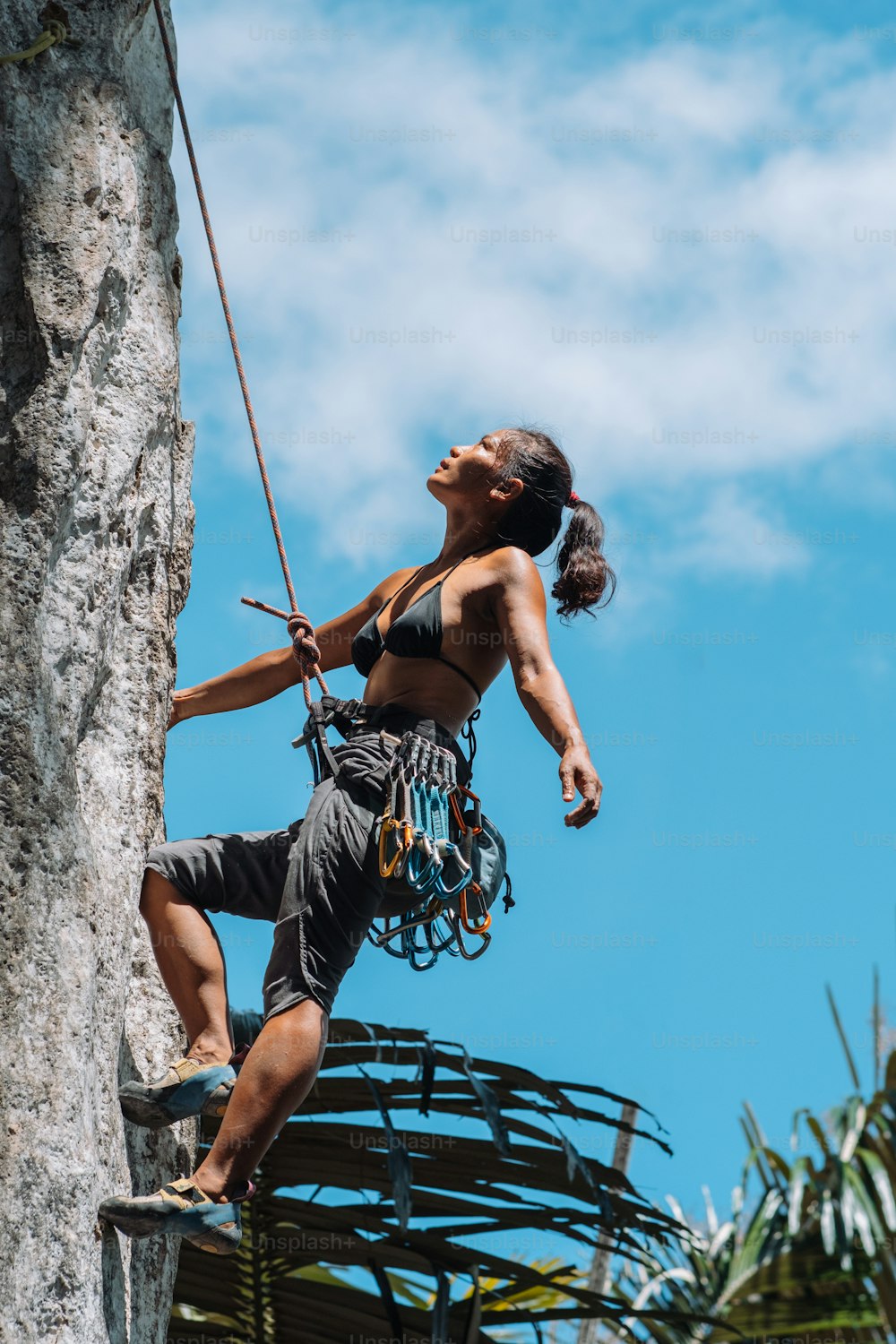 Une femme grimpe sur le flanc d’une falaise