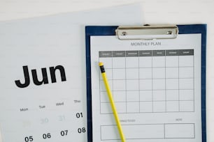 a clipboard with a calendar and a pen on it