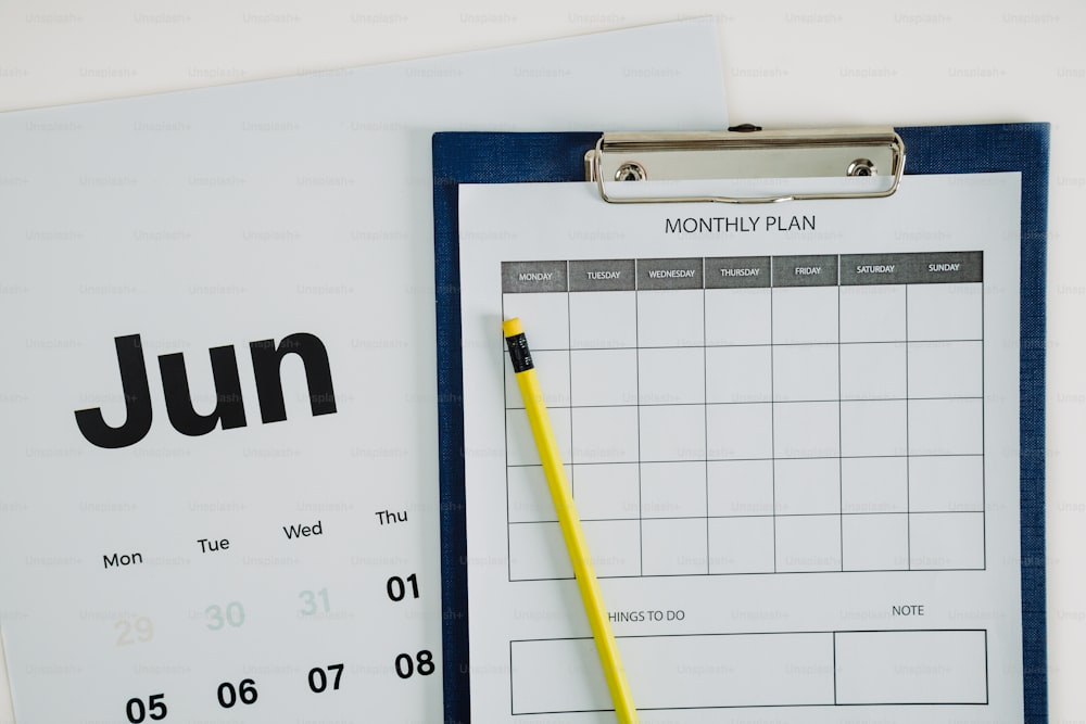 un presse-papiers avec un calendrier et un stylo dessus