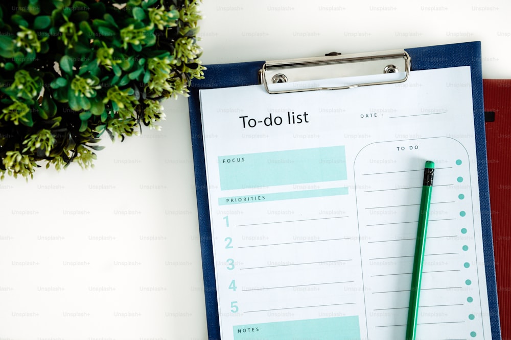 a clipboard with a to - do list on it next to a potted