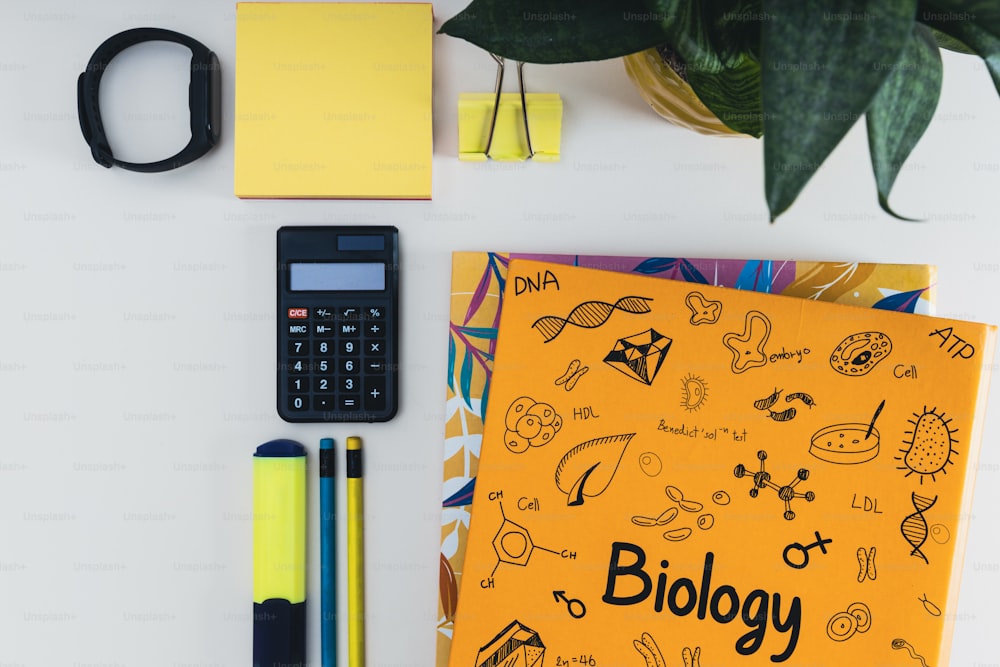 a yellow book with the word biology written on it next to a calculator