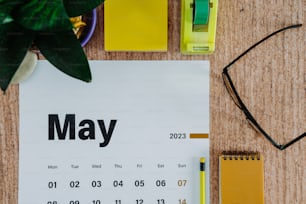 a calendar sitting on top of a table next to a plant