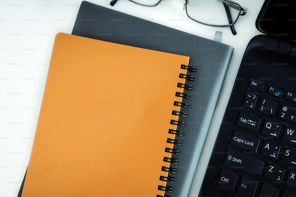 um caderno com caneta, óculos e calculadora