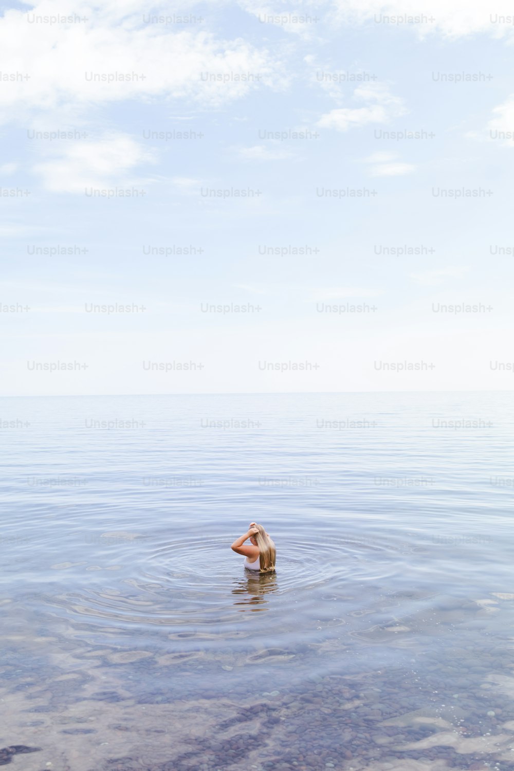a person standing in the water with their back to the camera
