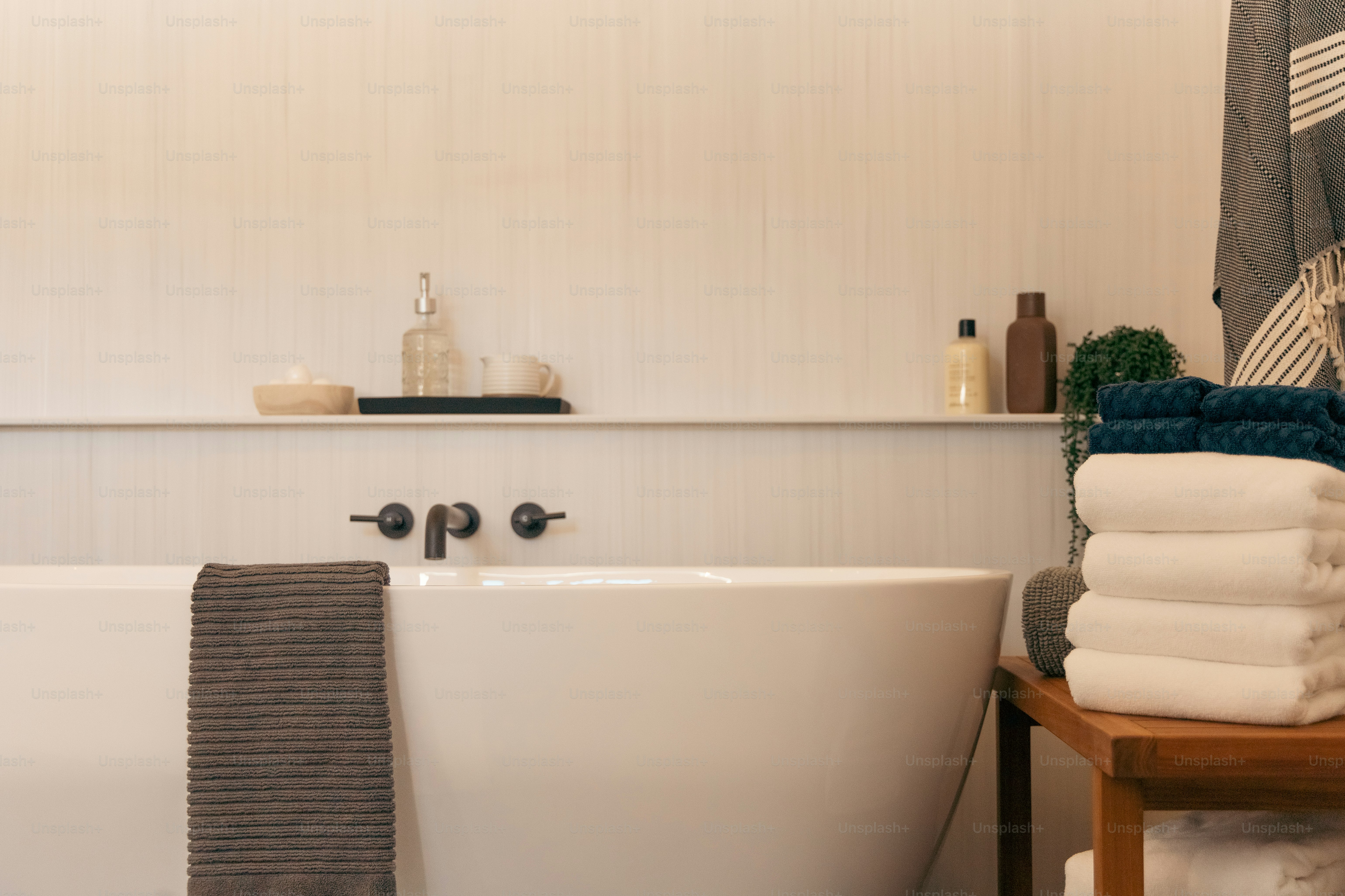 a white bath tub sitting next to a wooden table