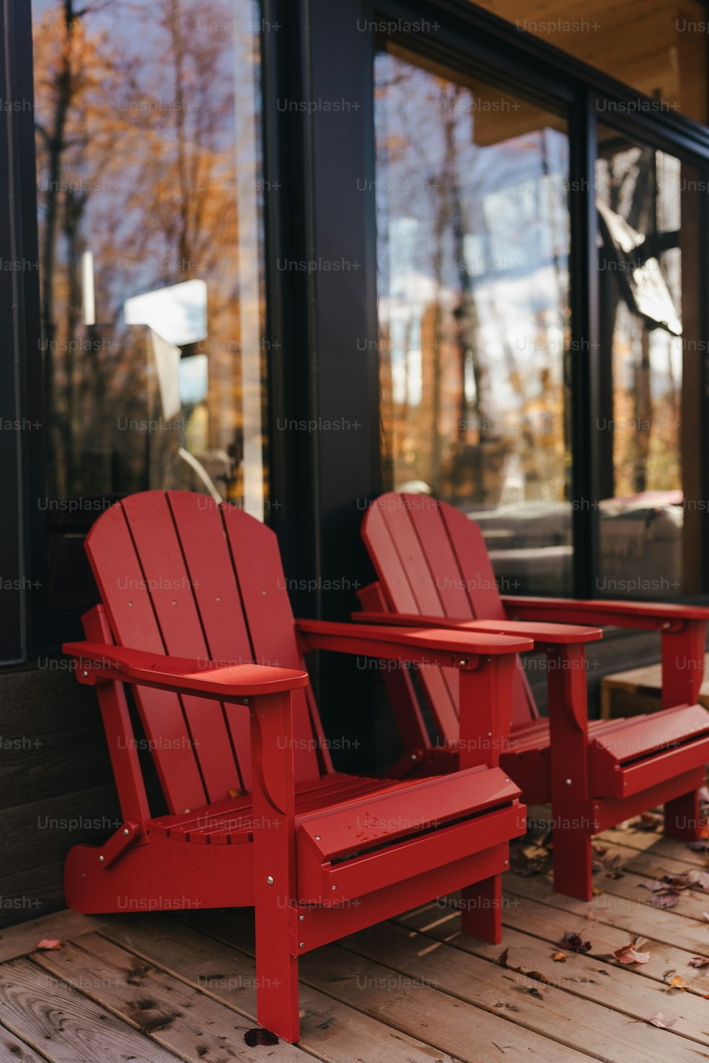 um par de cadeiras vermelhas sentadas em cima de um chão de madeira