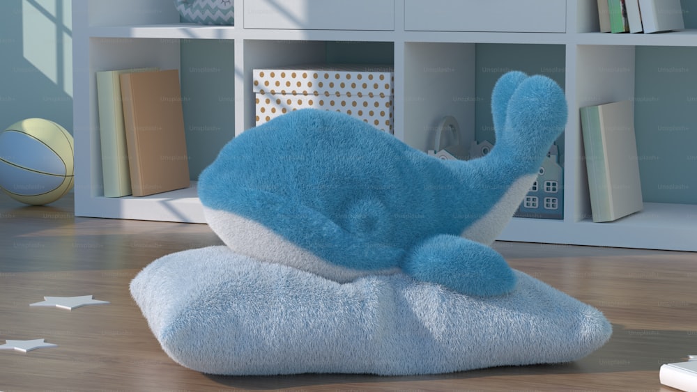 a blue stuffed animal laying on top of a wooden floor