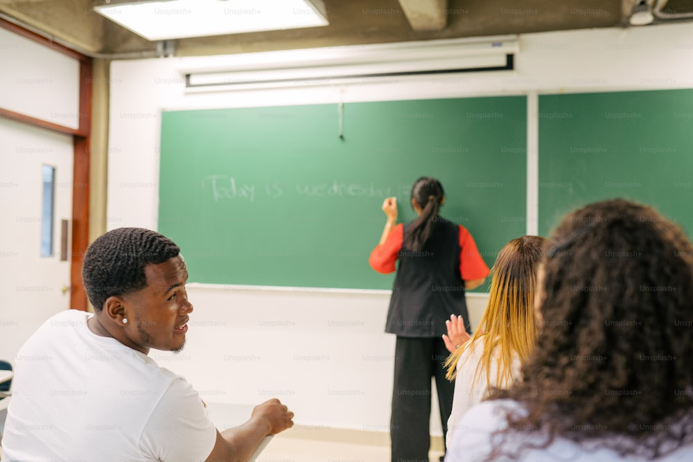 Un homme debout devant un tableau noir dans une salle de classe