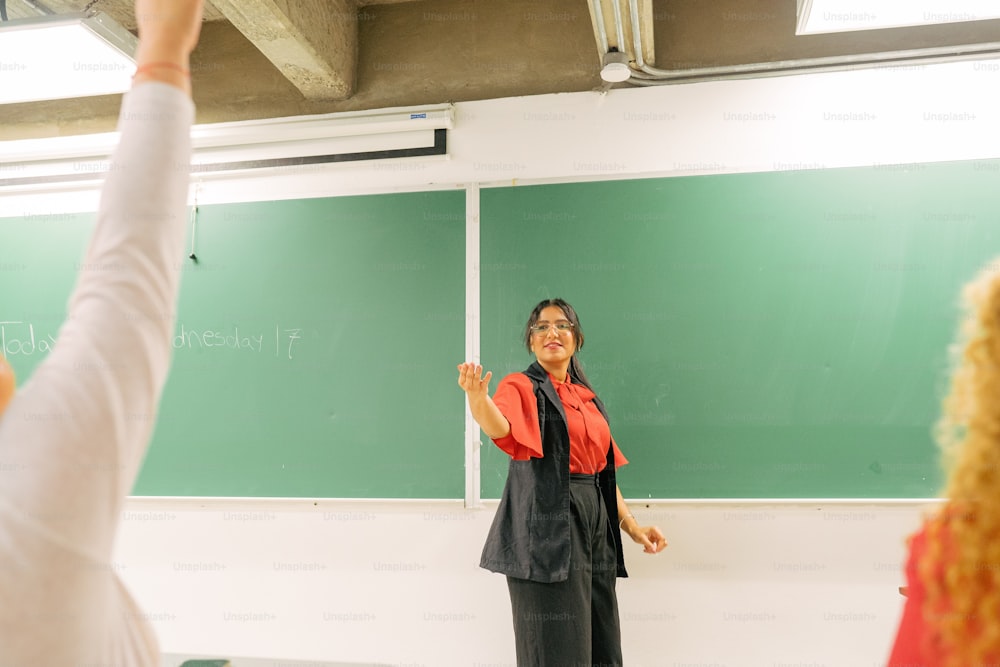 a woman standing in front of a blackboard giving a lecture