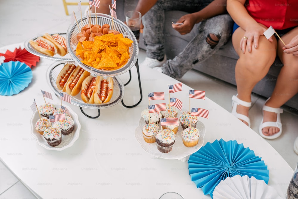 una mesa cubierta con cupcakes y cupcakes cubiertos de glaseado