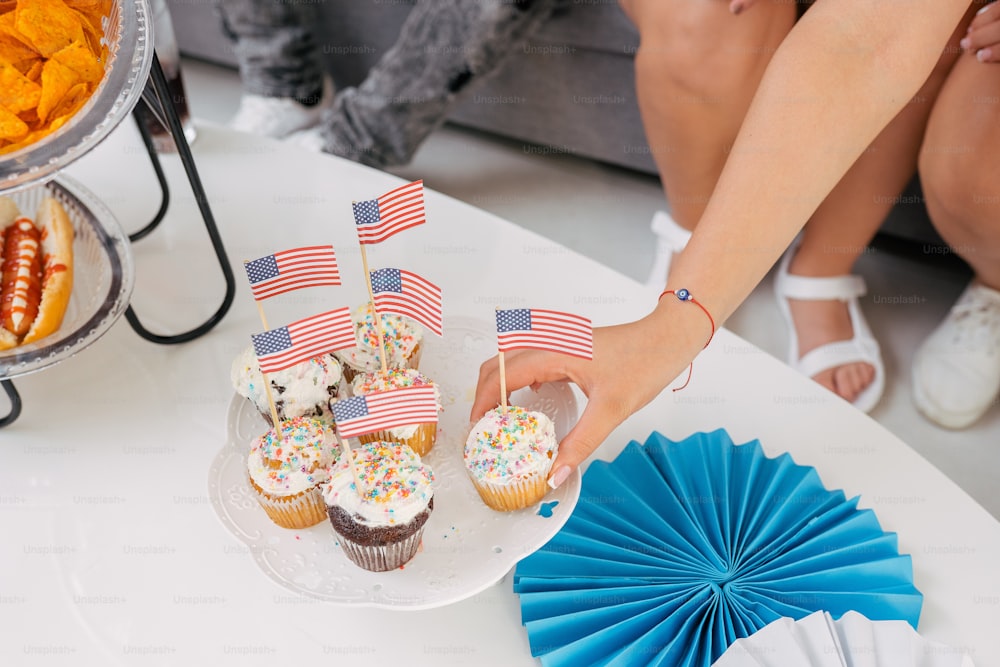 a table topped with cupcakes and cupcake flags