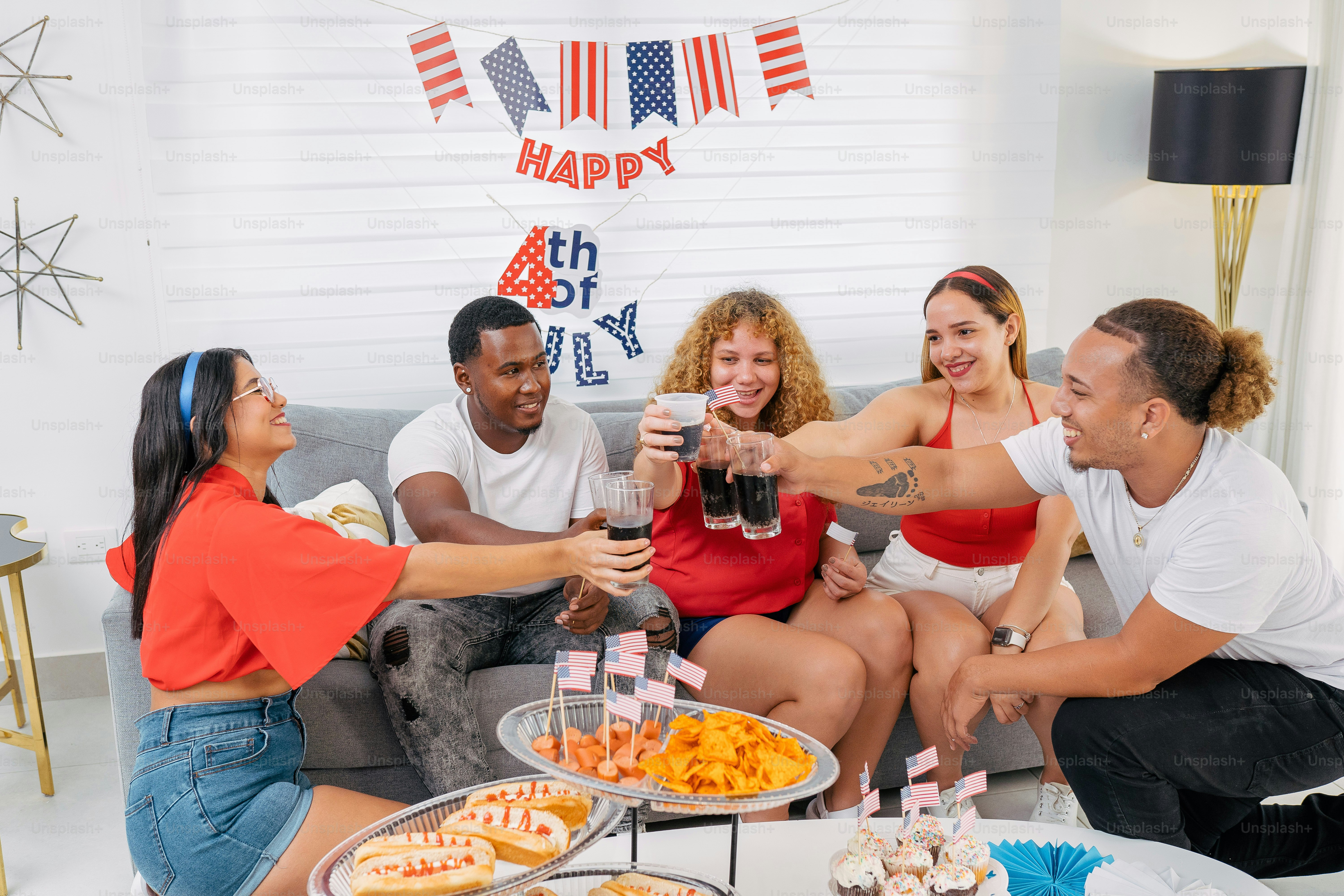 a group of people sitting on a couch toasting