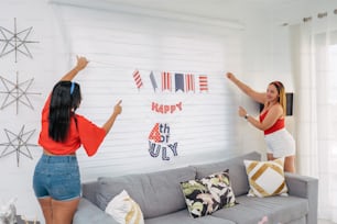 a couple of women hanging flags on a wall