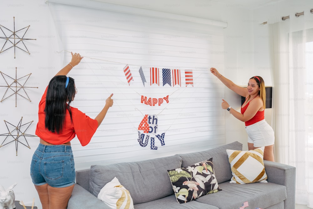 um casal de mulheres pendurando bandeiras em uma parede