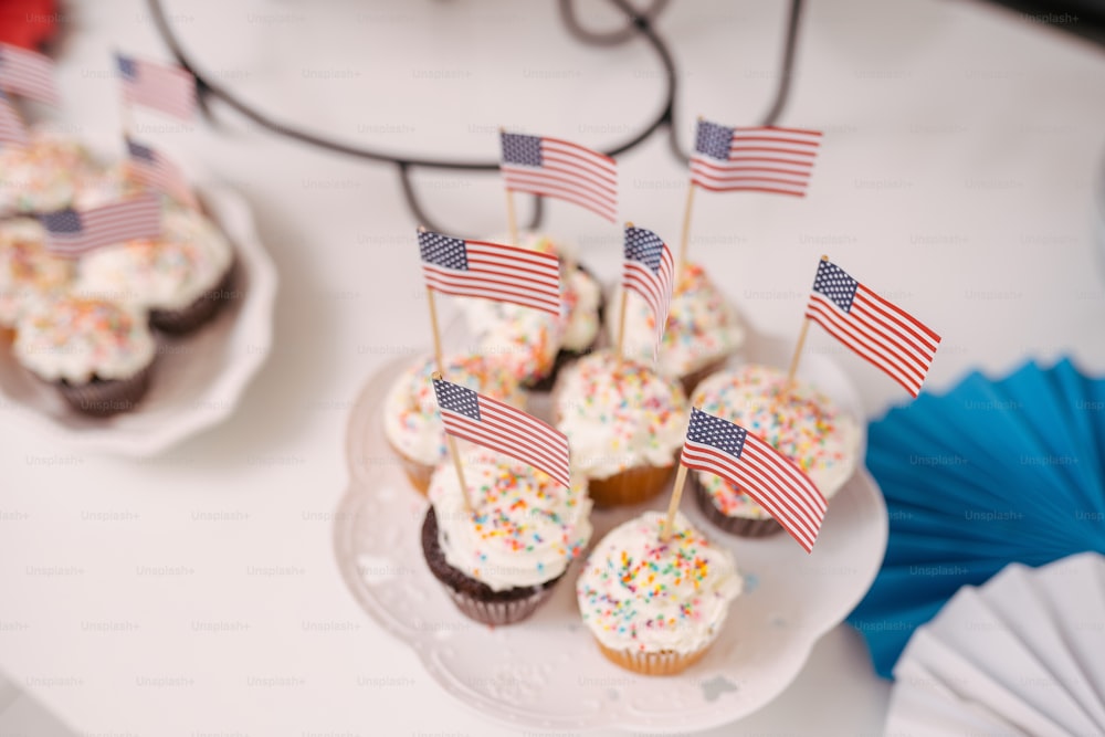 Un plato de cupcakes con banderas americanas en ellos
