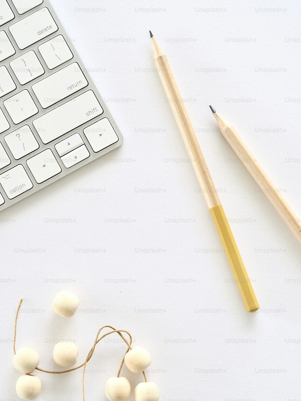 un teclado, lápices y algunas bolas de algodón en un escritorio