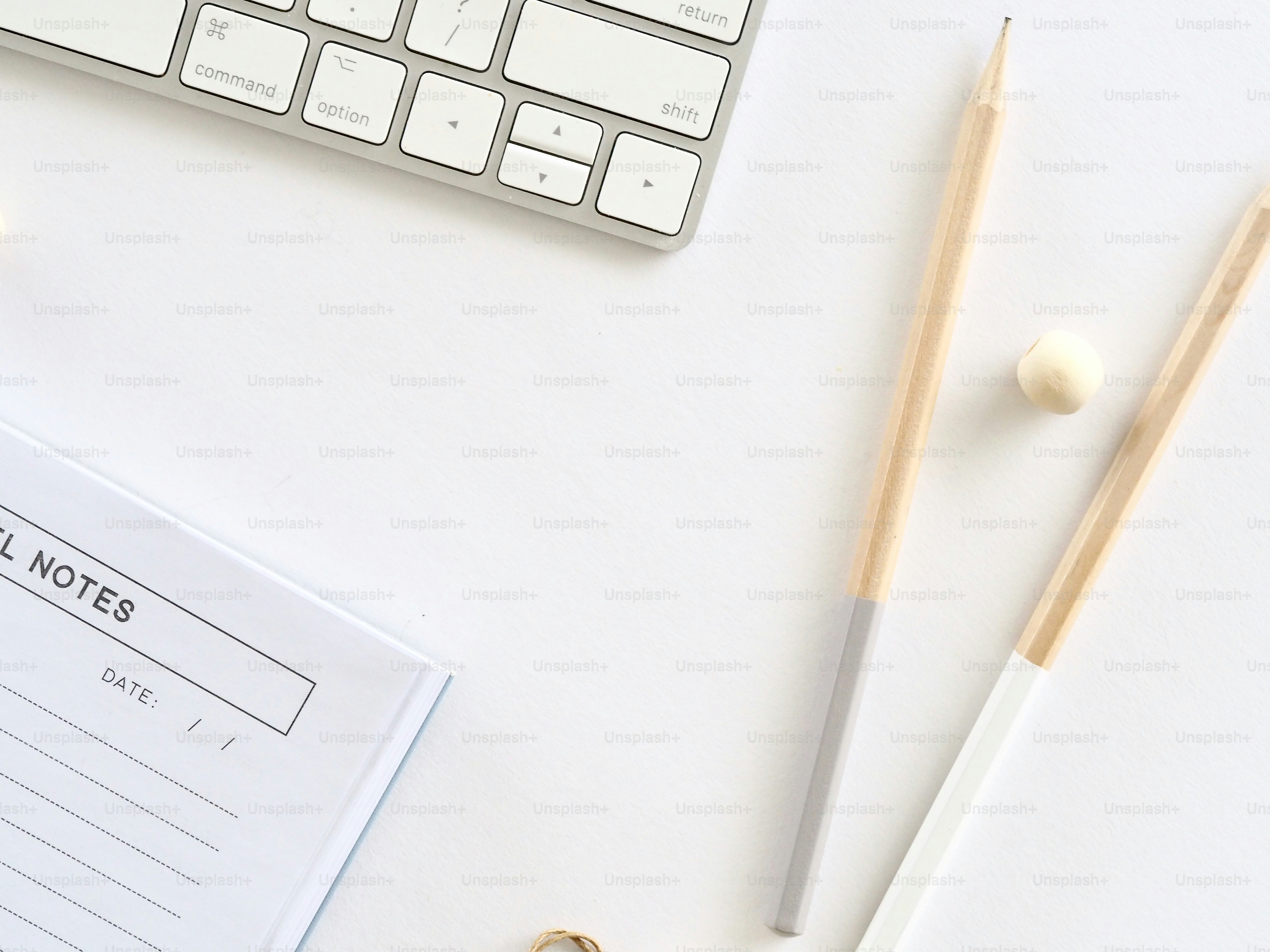 un bureau avec un clavier, des crayons et un bloc-notes