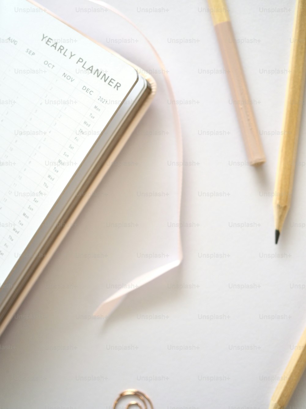 un cuaderno, lápices y un planificador sobre una mesa