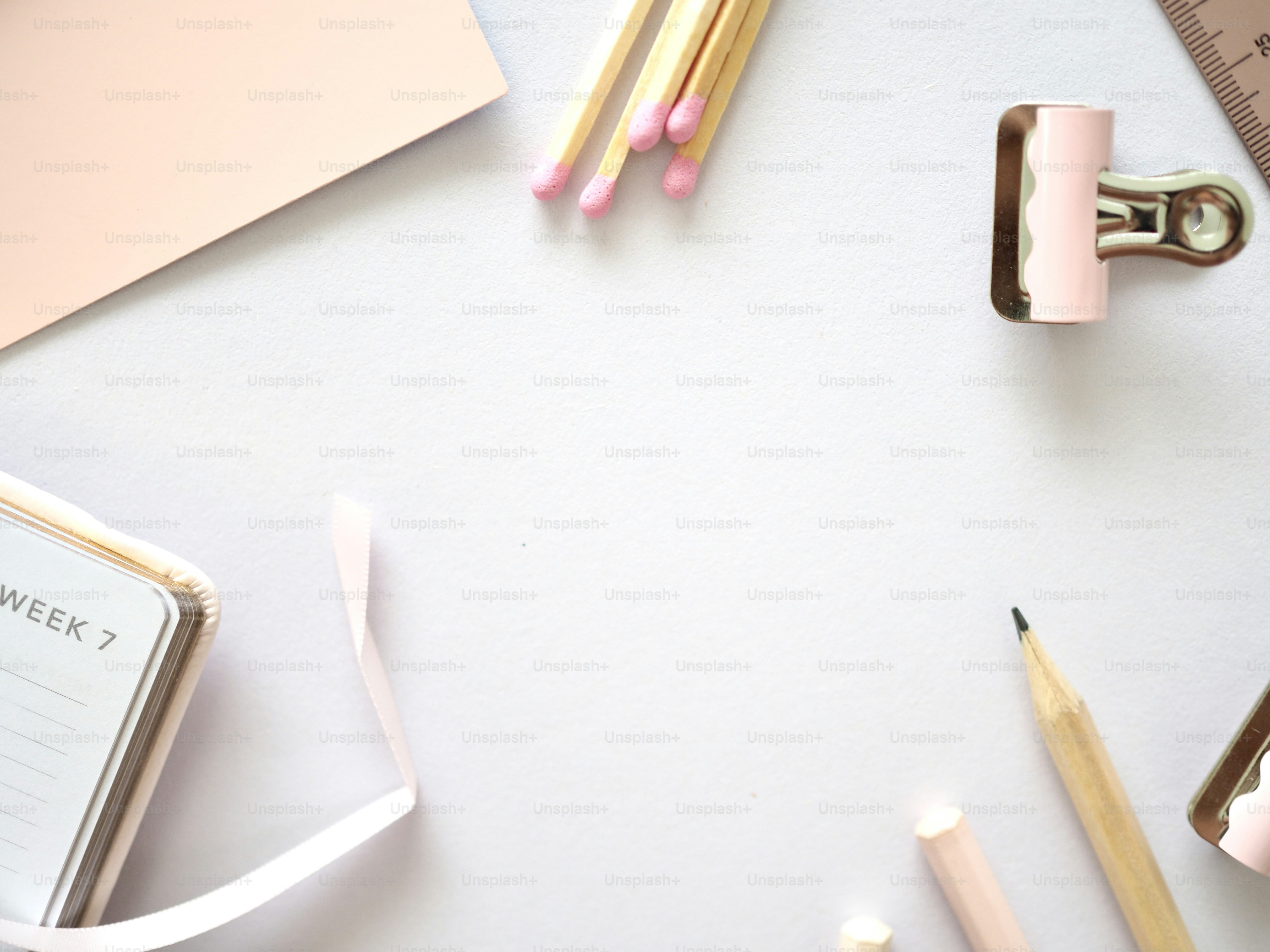 une table blanche surmontée de crayons et d’une règle