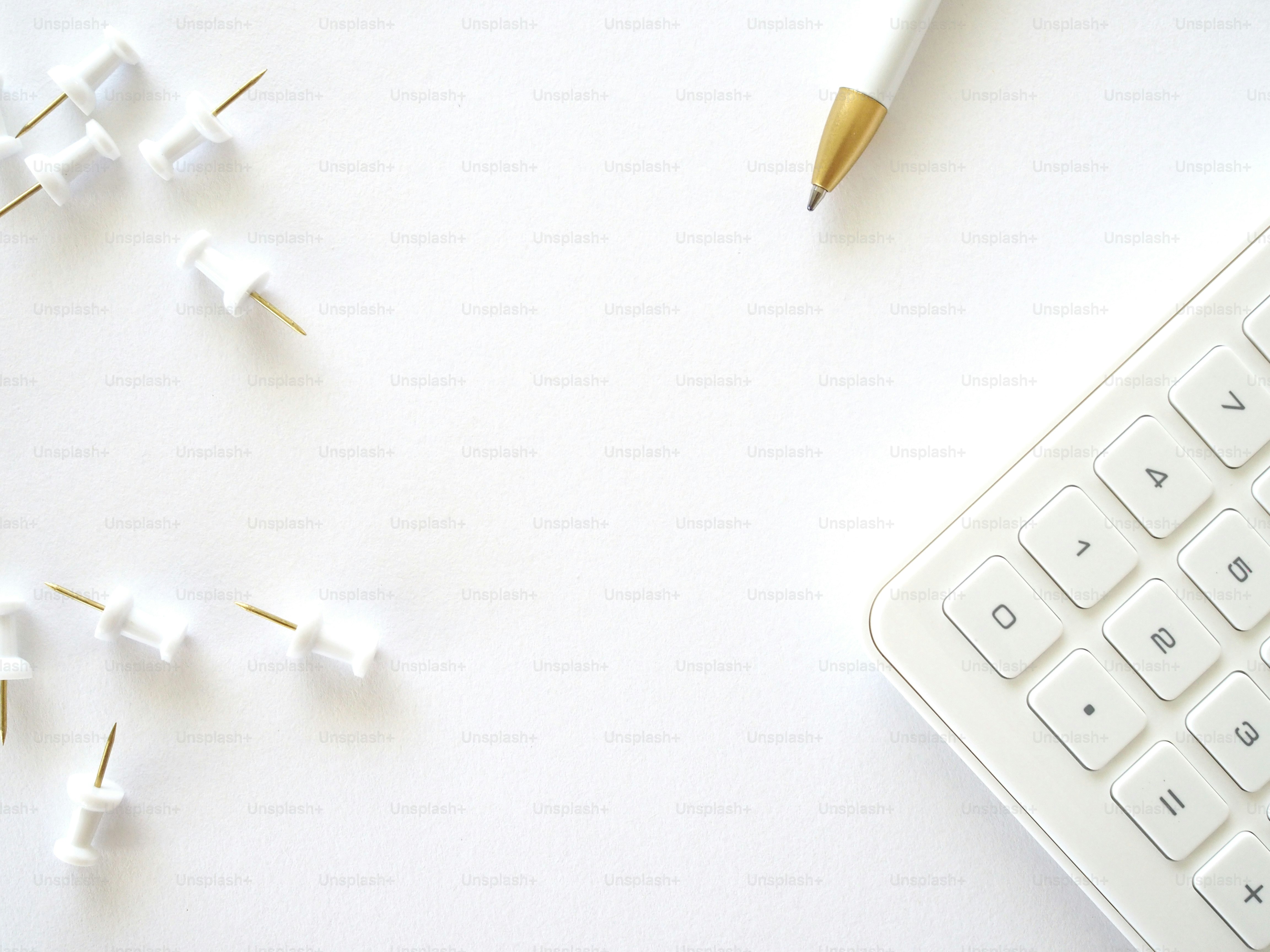 eine Tastatur und ein Stift auf weißer Fläche