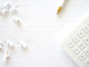 un clavier et un stylo sur une surface blanche