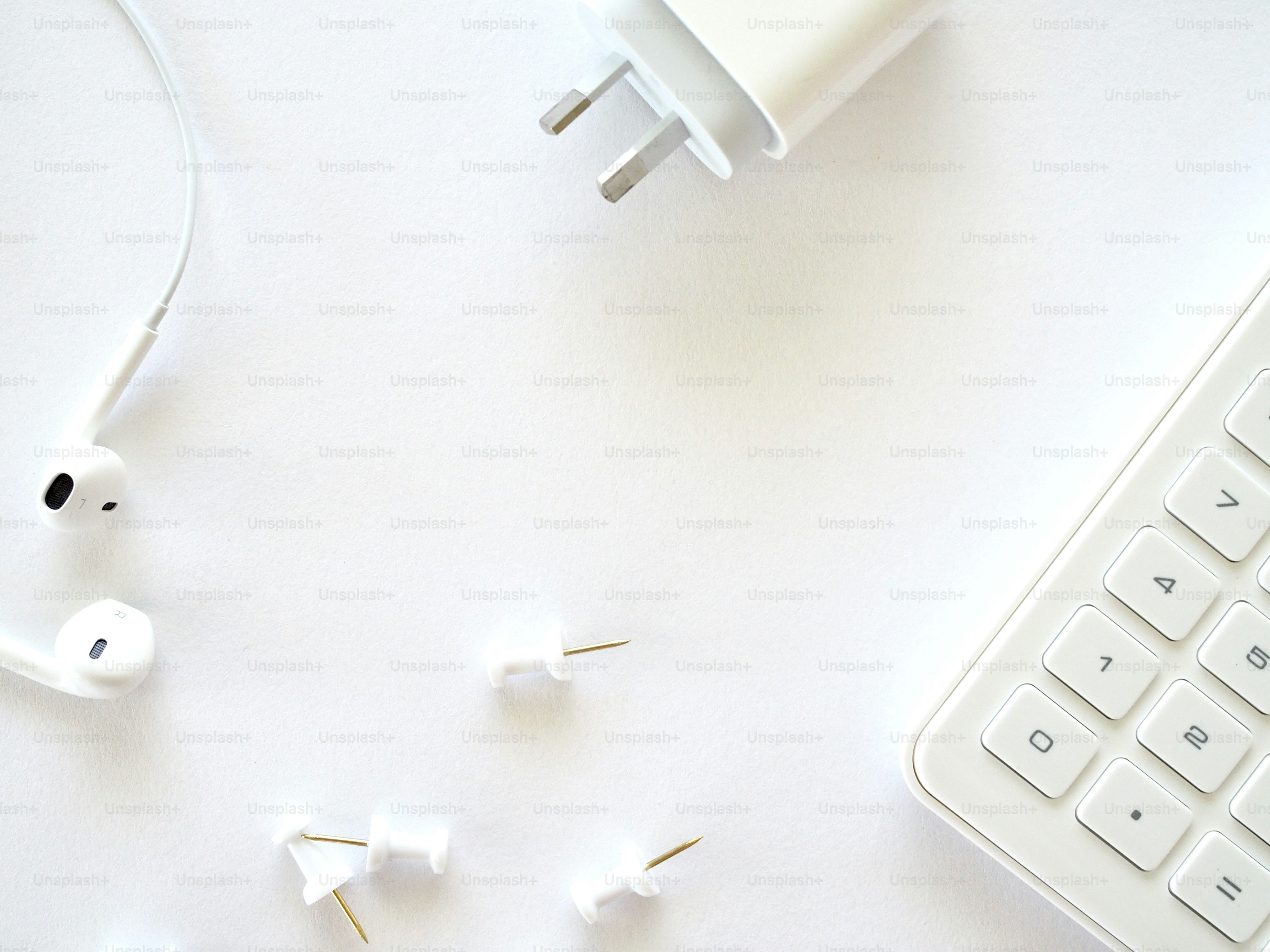 a keyboard and some ear buds on a table