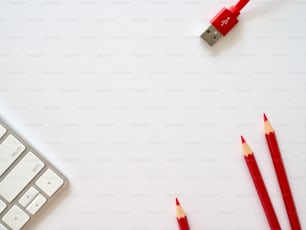 two red pencils are next to a keyboard