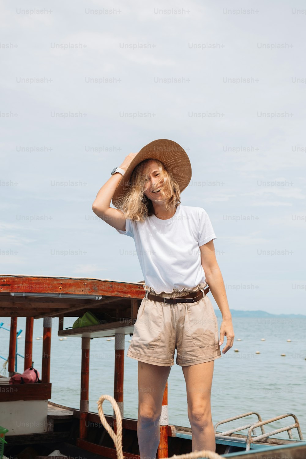 a woman wearing a hat standing on a boat