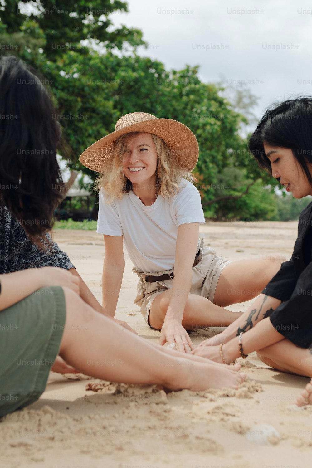 Un groupe de femmes assises au sommet d’une plage de sable