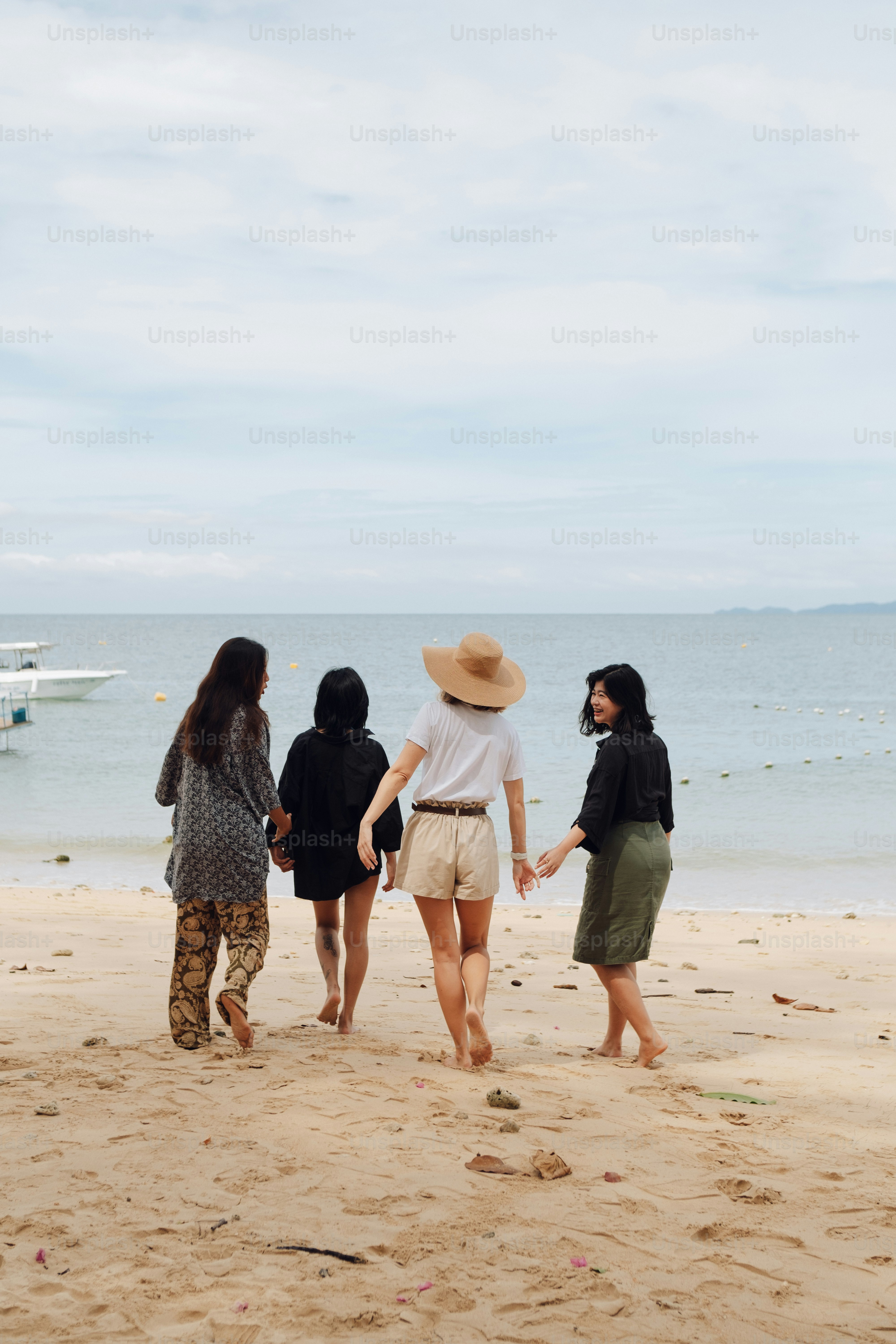 a group of people standing on top of a sandy beach