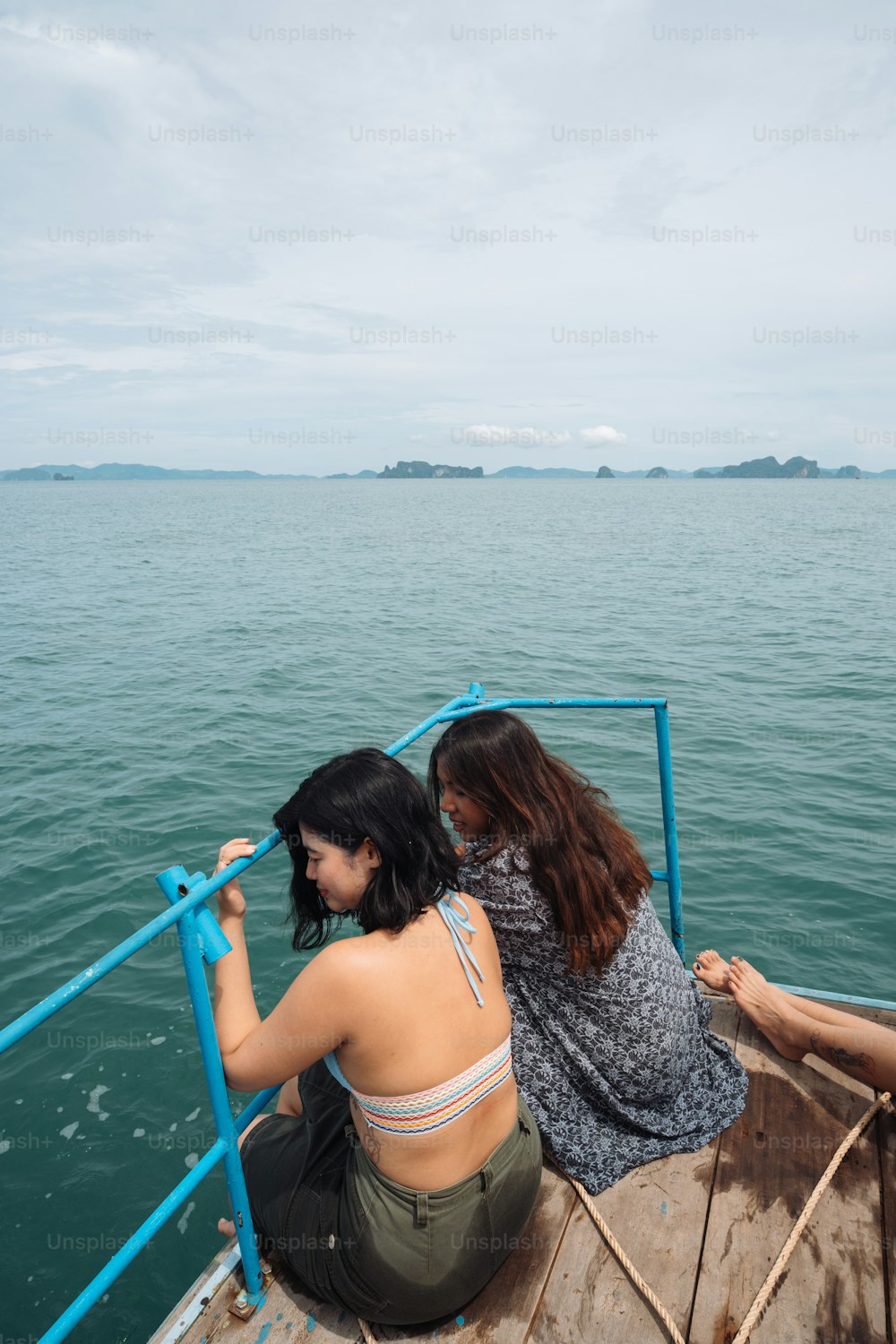 two women sitting on a boat in the water