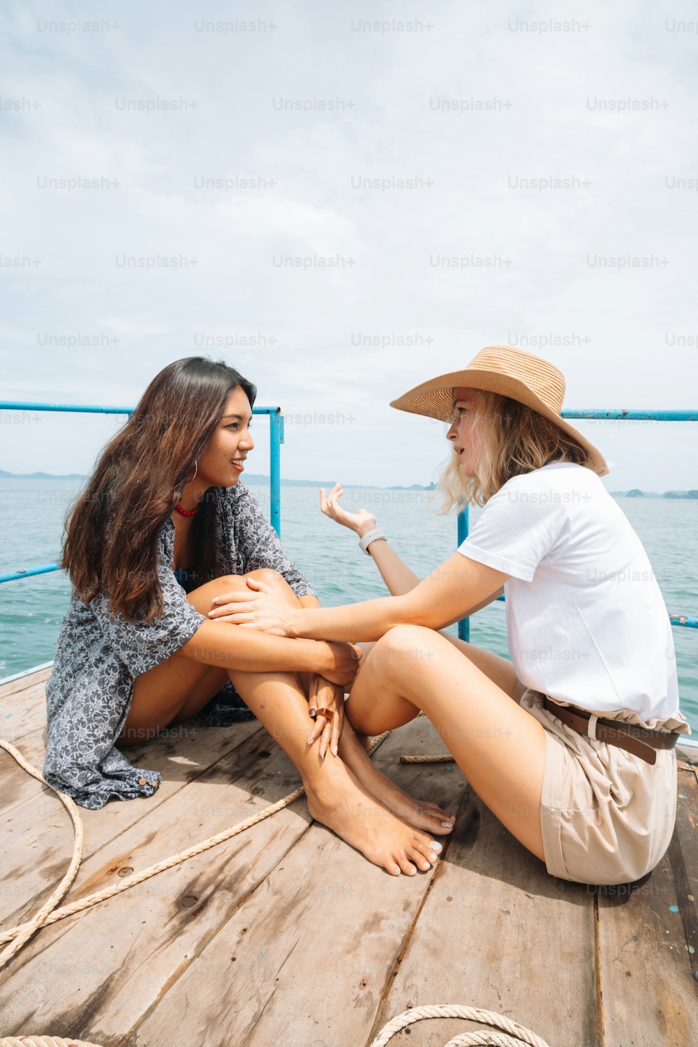 um casal de mulheres sentadas em cima de um barco de madeira
