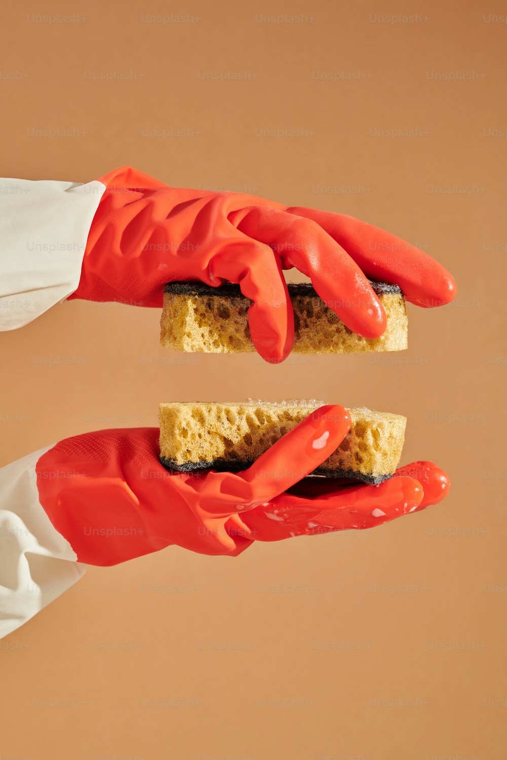 a pair of red gloves holding a piece of bread