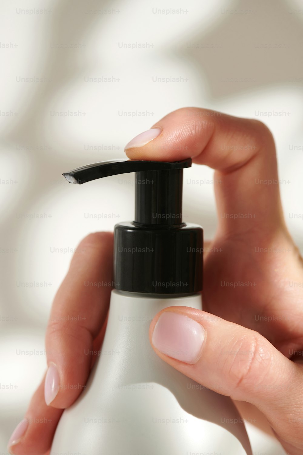 a woman's hand holding a bottle of lotion