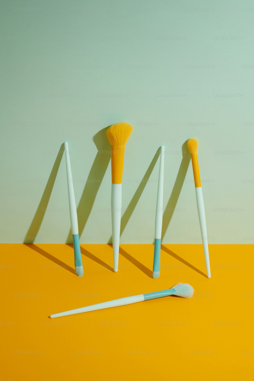 un gruppo di tre spazzolini da denti seduti sopra un tavolo giallo