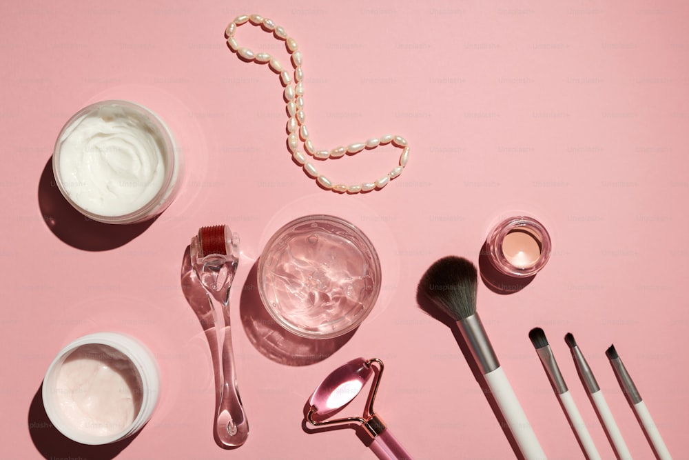 a pink table with makeup and other items on it