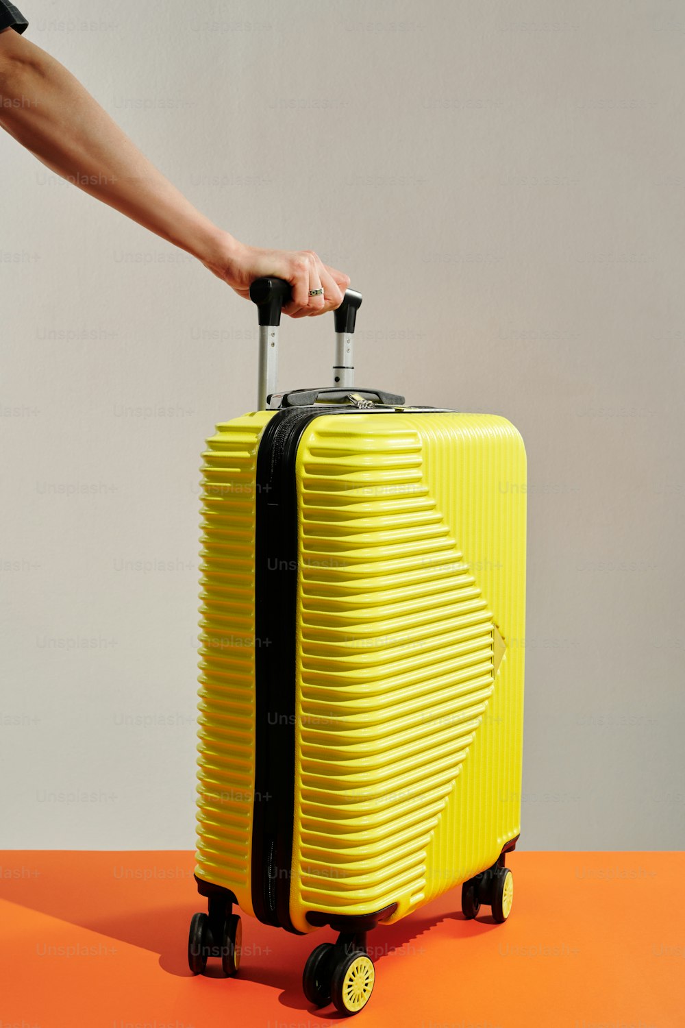 a person pulling a yellow suitcase on wheels