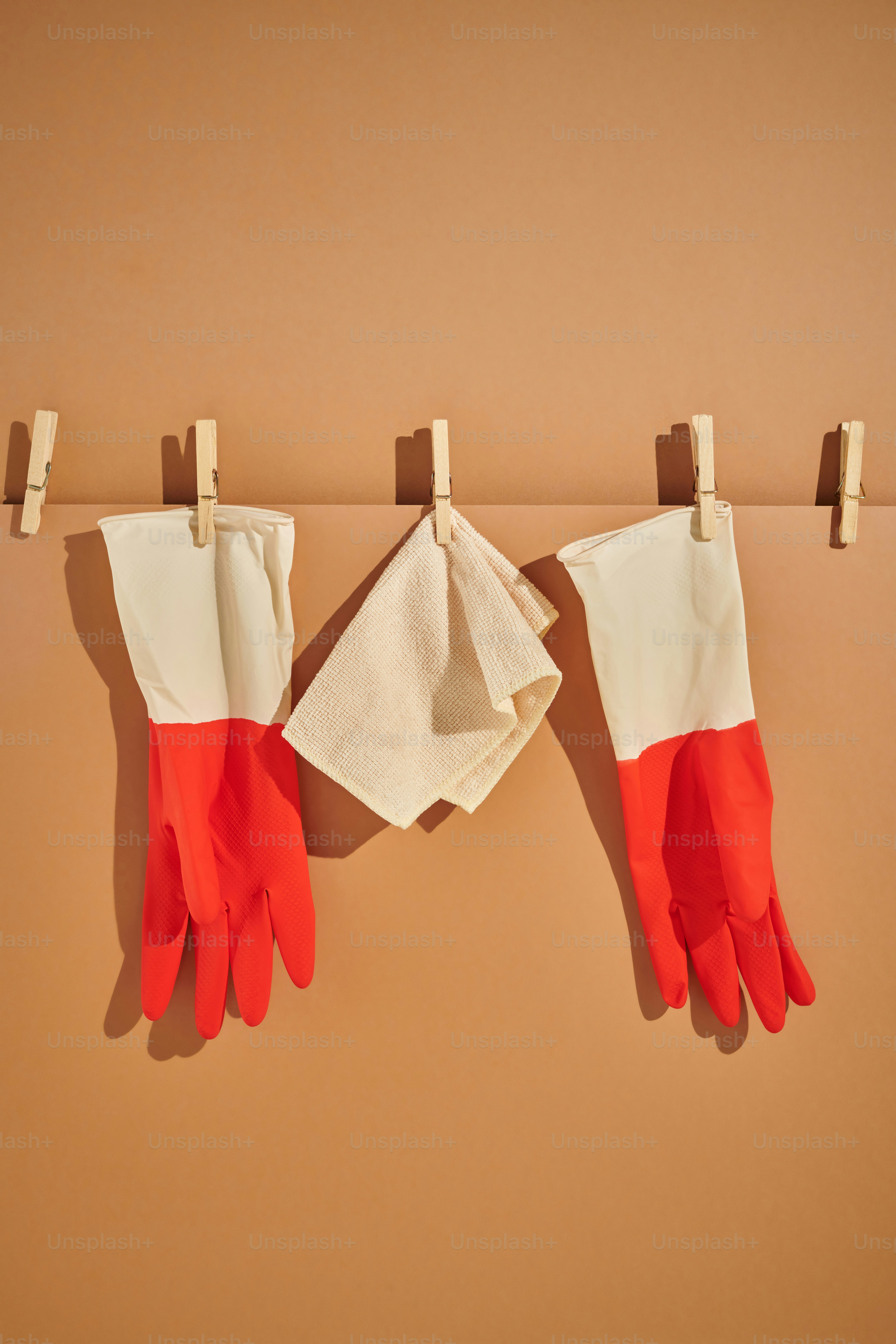 Un par de guantes rojos y blancos colgados en un tendedero