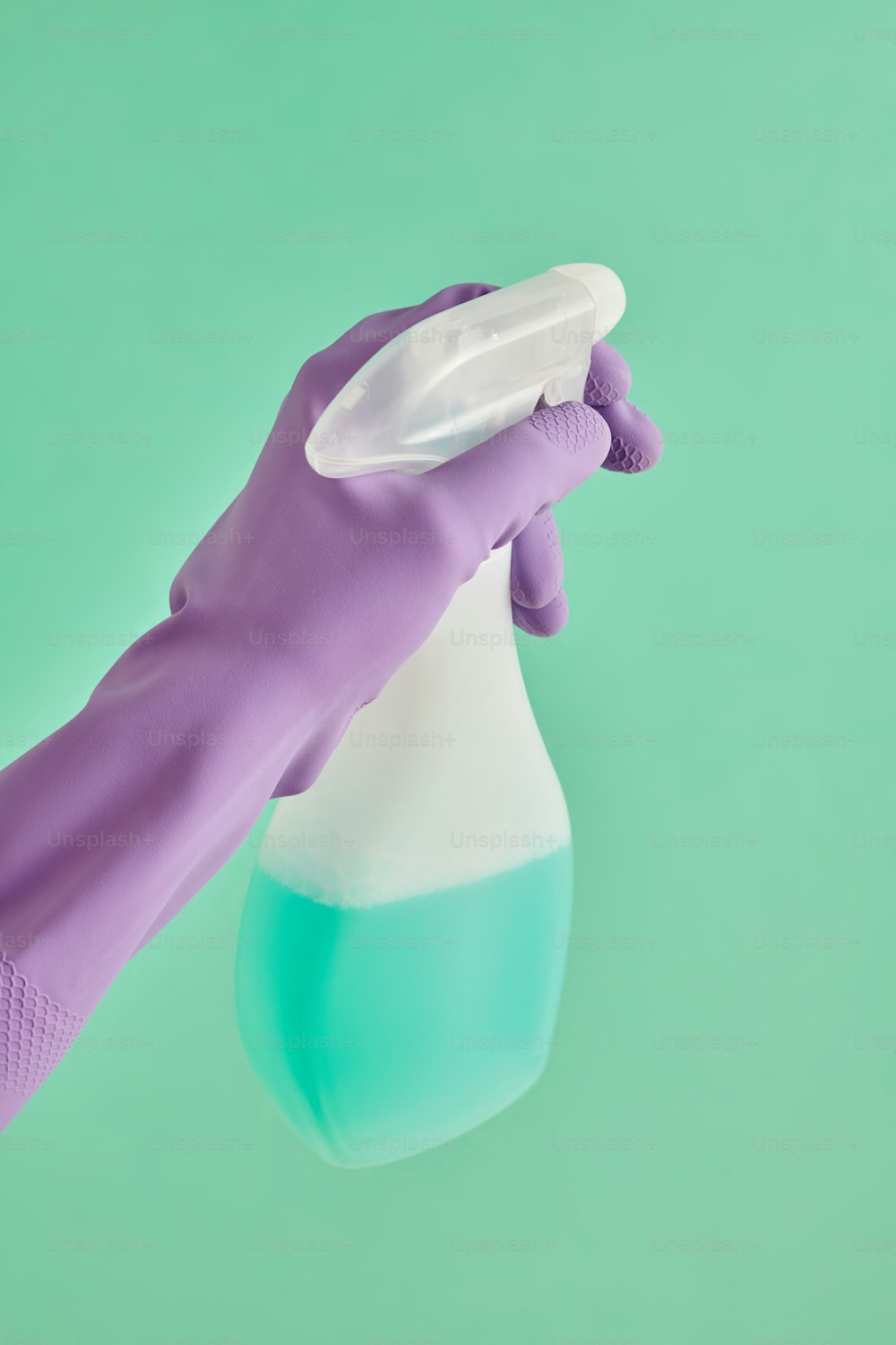 Una mano en un guante púrpura sosteniendo un recipiente azul y blanco