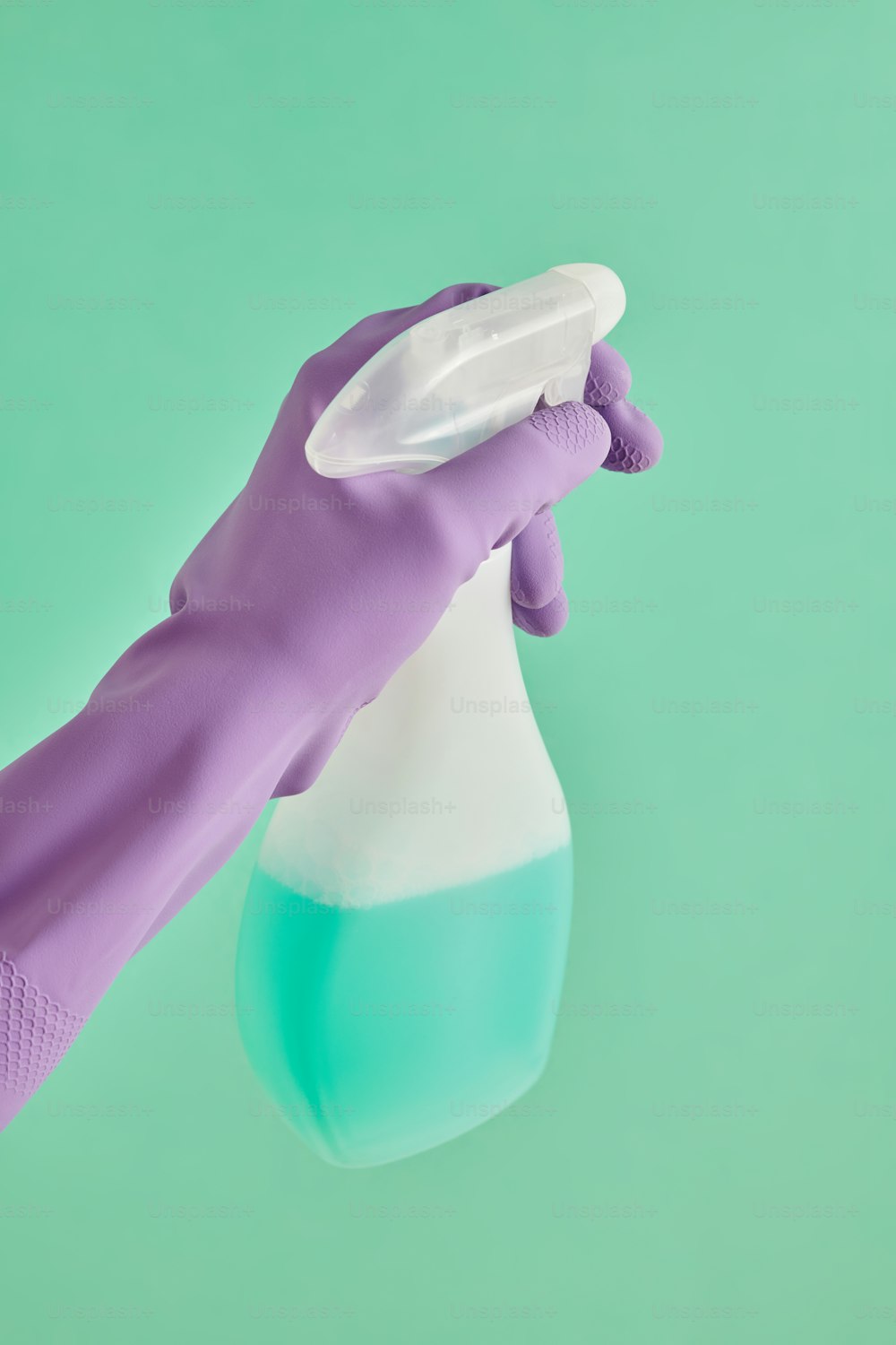 a hand in a purple glove holding a blue and white container