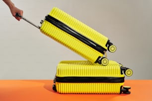 a pair of yellow luggage sitting on top of each other