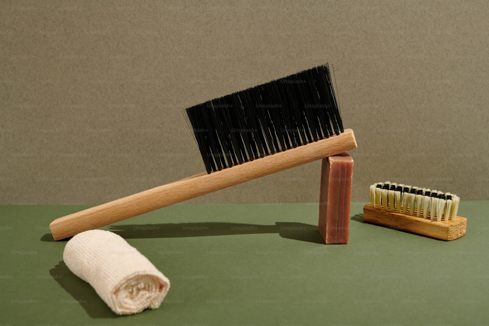 a wooden brush and a white towel on a green surface