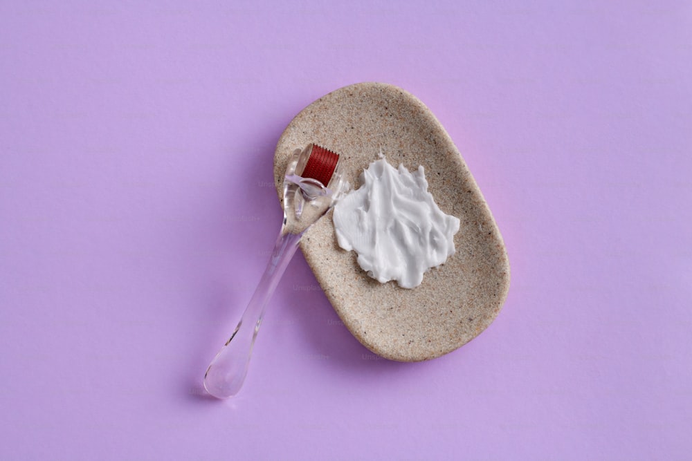 a spoon with whipped cream on it sitting on a plate