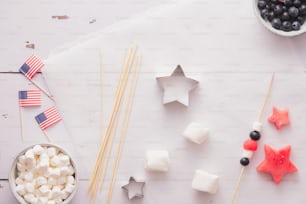 a table topped with marshmallows, berries and stars