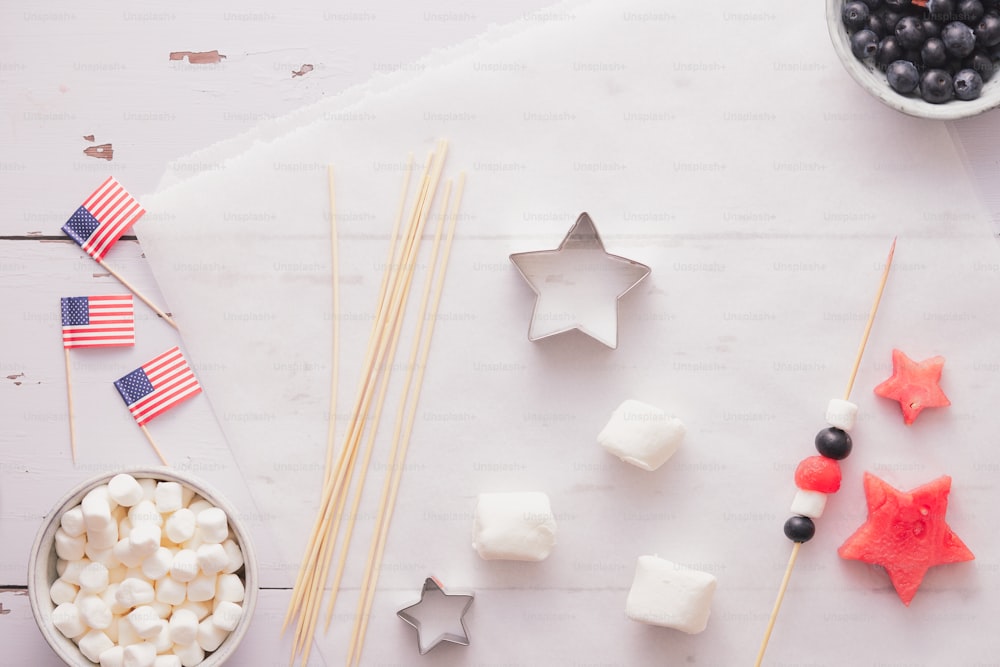 uma mesa coberta com marshmallows, bagas e estrelas