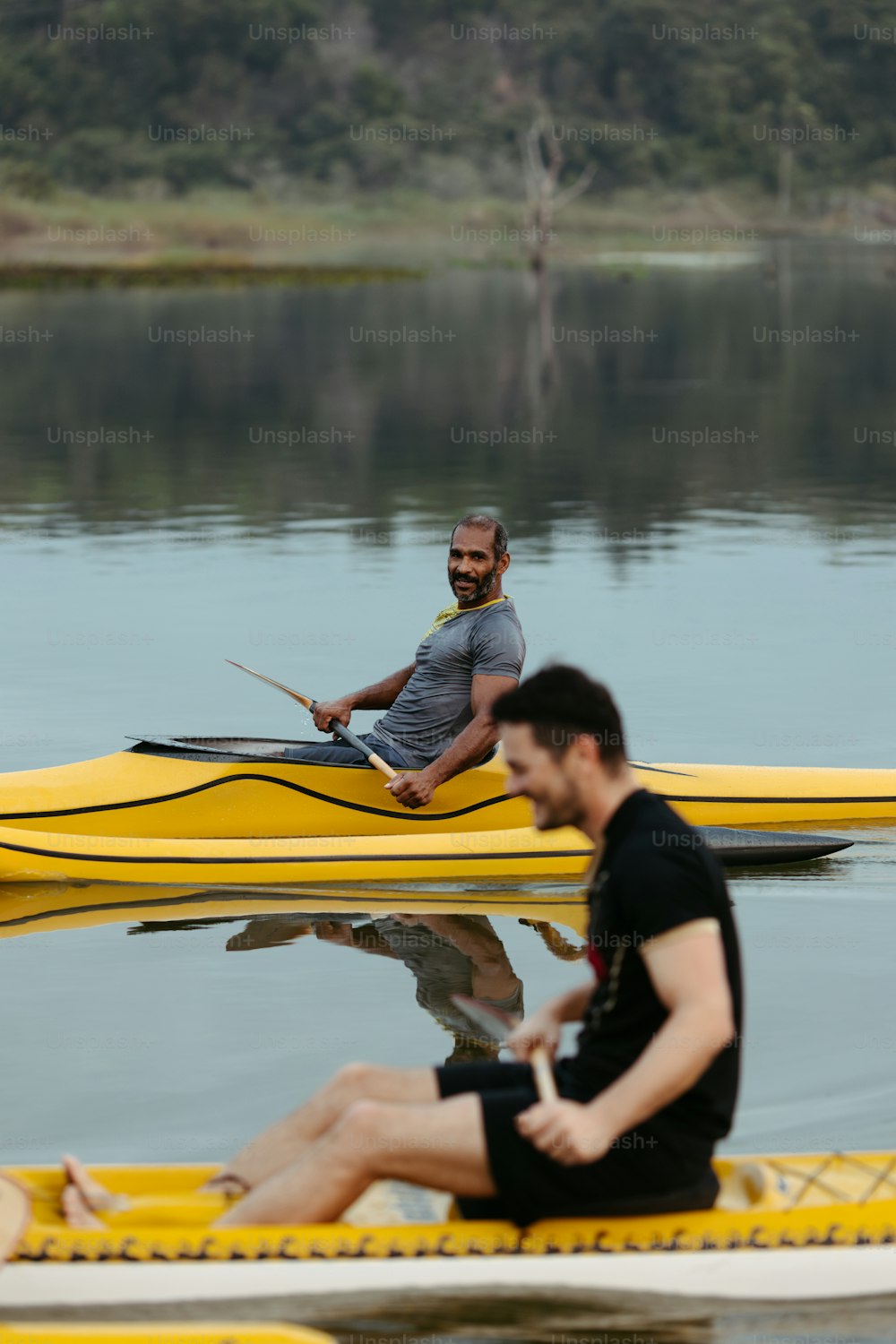 Un uomo seduto sulla cima di una barca gialla nell'acqua