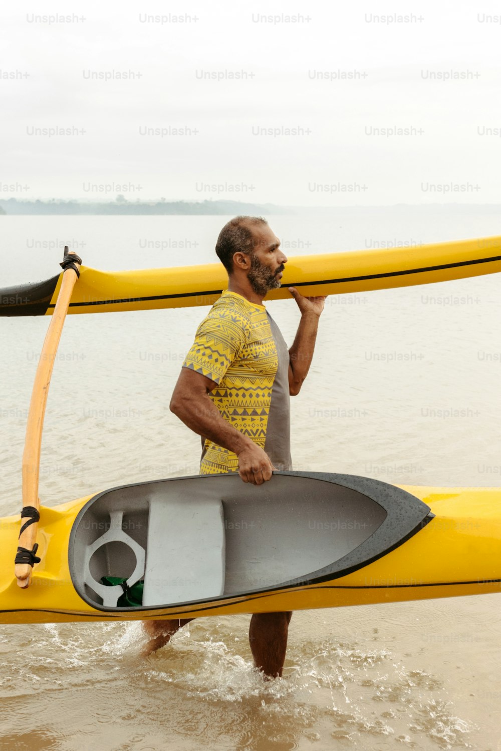 a man carrying a kayak out of the water
